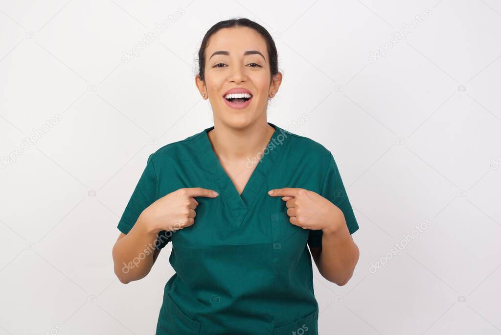 beautiful young nurse  points at her body, being in good mood 