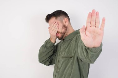 Model, gözleri avuç içi ile kaplar ve dur hareketi yapar, herkesten saklanmaya çalışır..