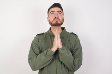 Kafkasyalı genç bir adam, yüzünde umut ifadesiyle birlikte çok duygusal ve endişeli bir şekilde dua ediyor. Soruyorum.