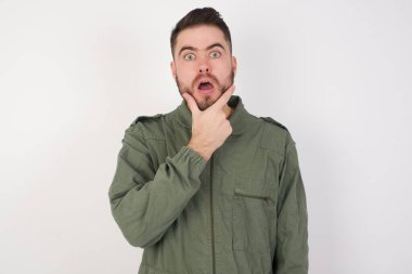 İnançsızlığa, şaşkınlığa ve elleri çenesinde olan hayret verici ifadeye hayran genç ve güzel bir adam.