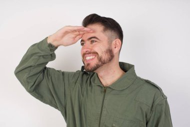 Kısa saçlı genç adam elini başının üstüne koyarak uzaklara bakıyor. Konsept aranıyor.