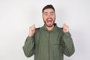 Genç yakışıklı beyaz adam şaşırdı ve şaşırdı. Kollarını kaldırıp gözlerini açtı. Kazanan konsept.