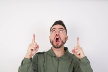 Genç, yakışıklı, beyaz adam şaşırmış ve şaşırmıştı. Parmaklarıyla işaret ediyor ve kollarını kaldırıyordu..
