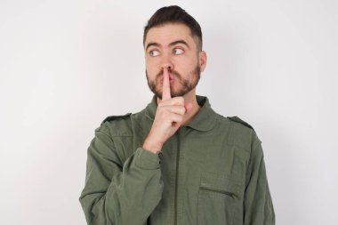 Model sessizlik jesti işaret parmağını dudaklara tutar, sessiz ol işareti yapar. Sırrımızı paylaşmamamızı istiyor.