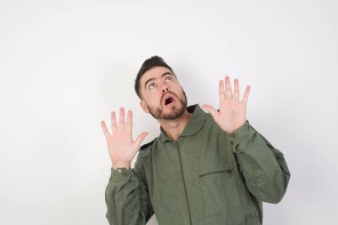 Model avuçlarını ileri doğru tutar ve tavandan korkuyla bakar kendini görünmez tehlikeden korumaya çalışır..