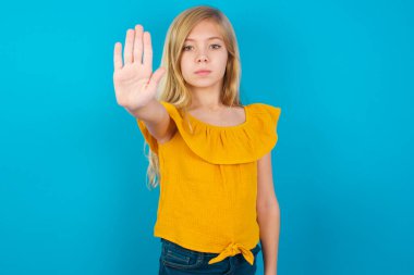 Küçük kız avucunun içi gibi şarkı söylemeyi bırakıyor. Yüzünde olumsuz ve ciddi bir jest olan uyarı ifadesi.