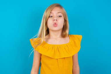 Küçük kız dudaklarıyla balık suratı yapıyor, çılgınca ve komik bir jest. Komik ifade.