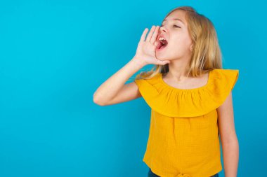 little girl shouting and screaming loud to side with hand on mouth. Communication concept. clipart