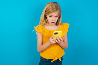 Odaklanmış küçük kız akıllı telefon, sosyal medya haberleri ya da önemli e-posta kullanıyor