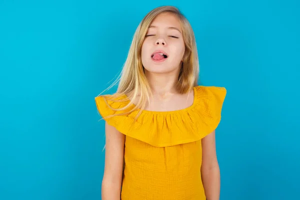 little girl sticking tongue out happy with funny expression. Emotion concept.