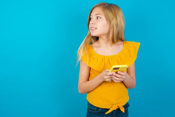Menina Segurando Smartphone Olhando Para Lado Copyspace Branco — Fotografia de Stock