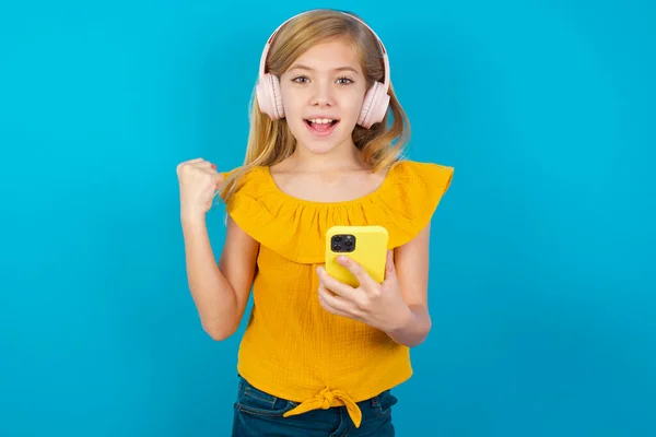 Petite Fille Positive Tient Téléphone Portable Moderne Connecté Casque Serre — Photo