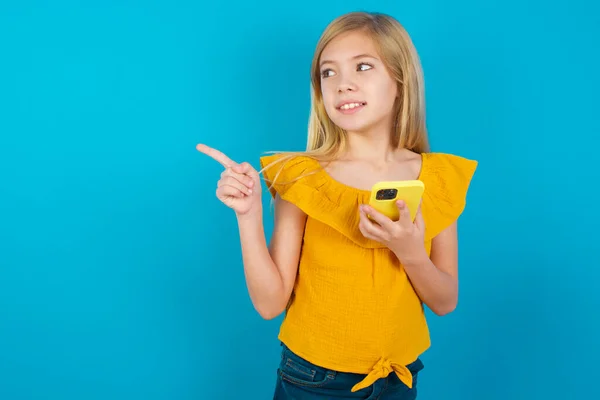 Ouah Excitée Petite Fille Avec Smartphone Pointant Vers Droite — Photo
