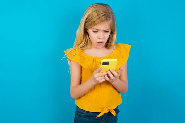 Odaklanmış küçük kız akıllı telefon, sosyal medya haberleri ya da önemli e-posta kullanıyor