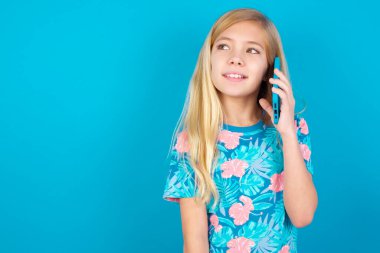 Keyifli görünüyor. Model güzel bir telefon görüşmesi yapıyor ve kenara bakıyor. Cep telefonuyla konuşurken güzel bir havası var ve gülümsüyor.