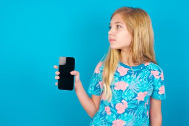 MODEL yeni cep telefonunu tutuyor ve gizemli görünüyor. Modern cep telefonunun boş görüntüsünü gösteriyor.