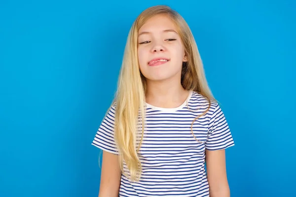 Kaukasisches Mädchen Mit Gestreiftem Hemd Vor Blauer Wand Das Fratzengesicht — Stockfoto