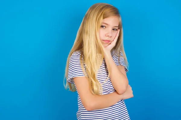 Bardzo Znudzona Biała Dziewczynka Pasiastej Koszuli Niebieską Ścianą Trzymająca Rękę — Zdjęcie stockowe