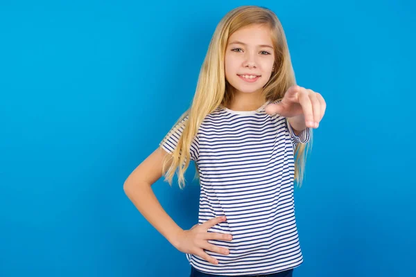 白人の子供の女の子を着て縞模様のシャツ青い壁に対してカメラを指して満足し 自信を持って フレンドリーな笑顔で あなたを選択 — ストック写真