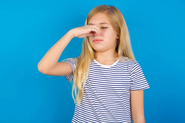 Blank Meisje Draagt Gestreept Hemd Tegen Een Blauwe Muur Ruikt — Stockfoto