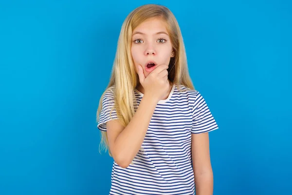 Chica Caucásica Con Camisa Rayas Contra Pared Azul Pareciendo Fascinado —  Fotos de Stock