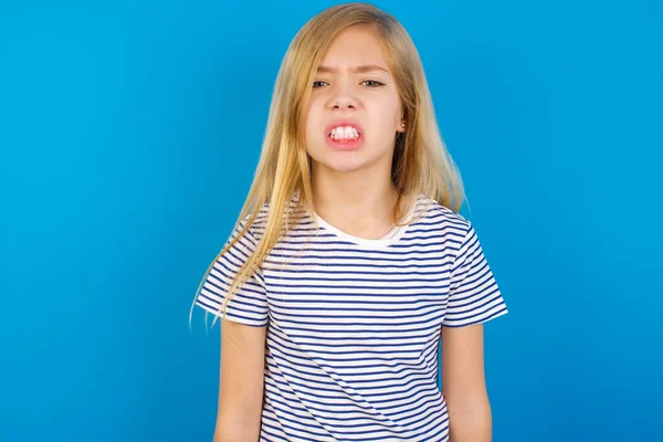 Кавказька Дівчинка Одягнена Смугасту Сорочку Проти Синьої Стіни Тримає Зуби — стокове фото