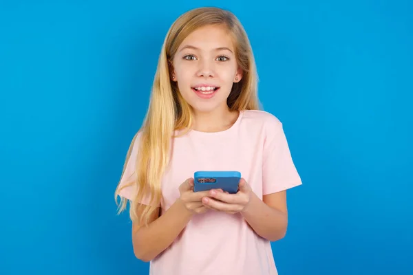 Ενθουσιασμένος Καυκάσιος Κορίτσι Φορώντας Ροζ Shirt Κατά Μπλε Τοίχο Κρατώντας — Φωτογραφία Αρχείου