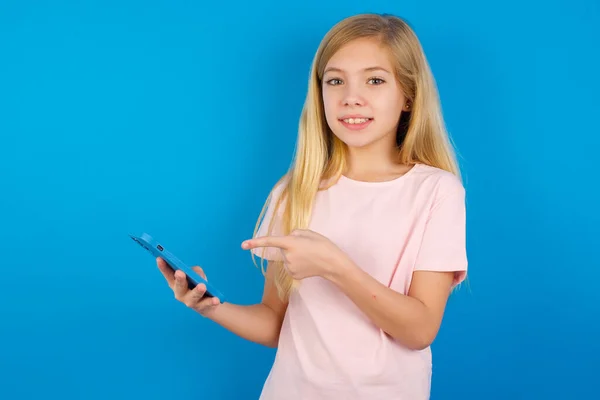 Ragazza Caucasica Indossa Rosa Shirt Contro Muro Blu Tenendo Mano — Foto Stock