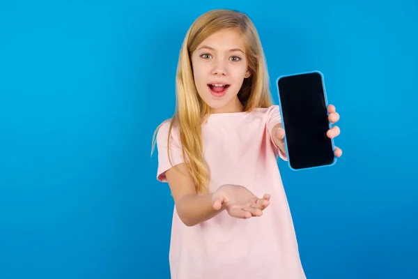 Caucasian Kid Girl Wearing Pink Shirt Blue Wall Mobile Presenting — Stock Photo, Image