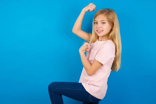 興奮した白人の子供の女の子のプロフィール写真ピンクのシャツを身に着けています青い壁に対して調達拳を祝います黒金曜日のショッピング — ストック写真