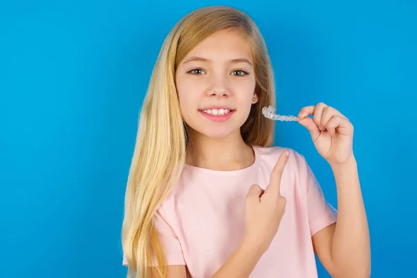 Menina Branca Vestindo Camisa Rosa Contra Parede Azul Segurando Aligner — Fotografia de Stock