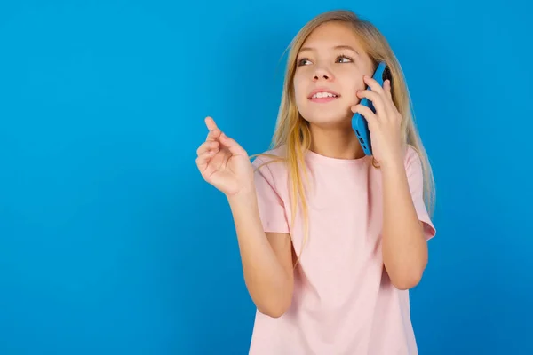 Caucásico Niña Usando Camisa Rosa Contra Pared Azul Habla Teléfono —  Fotos de Stock