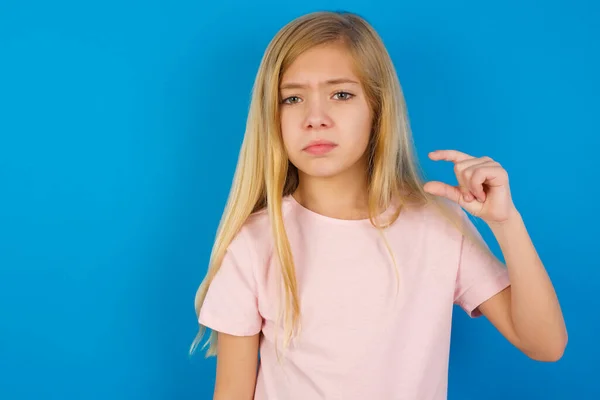 Ontevreden Blanke Meisje Draagt Roze Shirt Tegen Blauwe Muur Vormen — Stockfoto