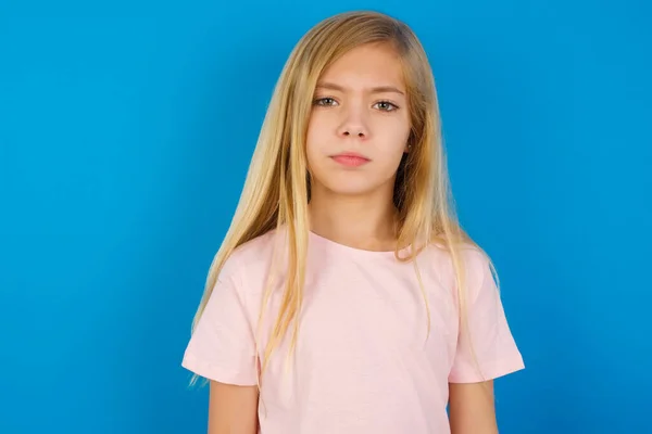 Kavkazská Dívka Růžové Košili Proti Modré Stěně Ukazující Dolů Prsty — Stock fotografie