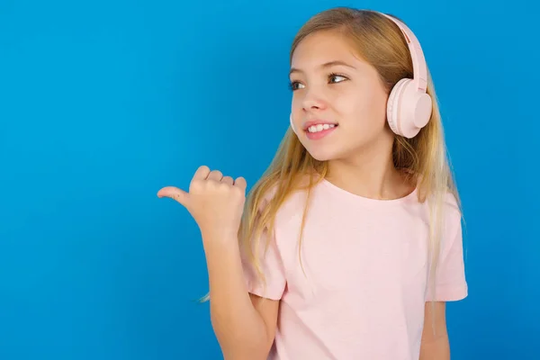 Blank Kind Meisje Dragen Jurk Tegen Blauwe Muur Luistert Audio — Stockfoto