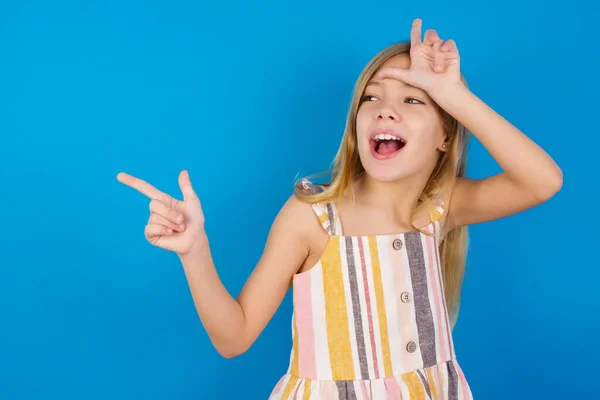 Menina Branca Usando Vestido Contra Parede Azul Mostrando Sinal Perdedor — Fotografia de Stock