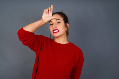 Genç İspanyol kadın, alnında parmakları olan insanlarla dalga geçiyor. Ezik jestler yapıyor, alay ediyor, hakaret ediyor..