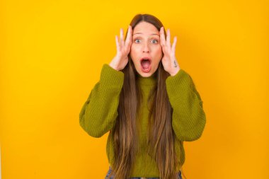 Korkmuş yüzlü genç bir kadın, elleri başının üstünde, çenesi düşmüş, müthiş bir ifadesi var. Omg kavramı