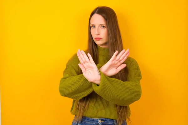 若い女性は腕と手のひらを交差させて否定的なサインをしたり怒りの顔をしたり — ストック写真