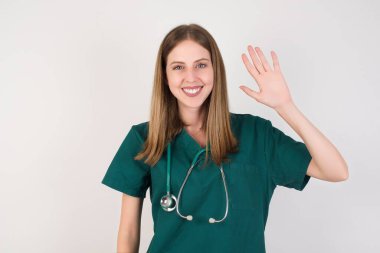 Gülümseyen genç, güzel hemşire kameraya el sallıyor.