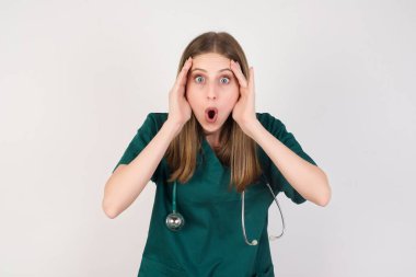 Şaşırmış genç, güzel hemşire kameraya bakıyor.