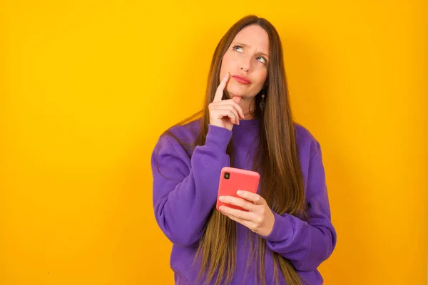 Mujer Joven Piensa Profundamente Algo Utiliza Teléfono Móvil Moderno Trata —  Fotos de Stock