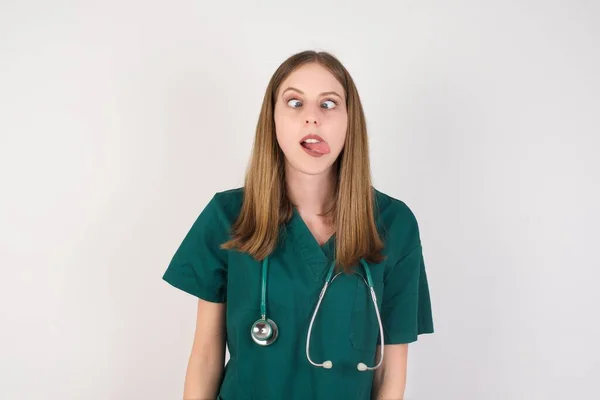 Hermosa Joven Caucásica Enfermera Mostrando Lengua Sobre Fondo Blanco — Foto de Stock