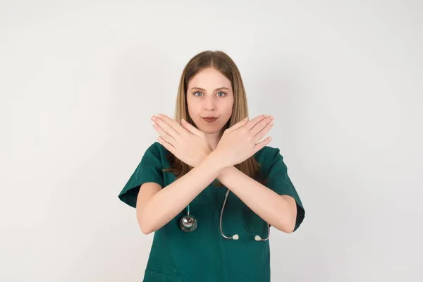 若い看護師と聴診器は白地に否定的な兆候を示しています — ストック写真