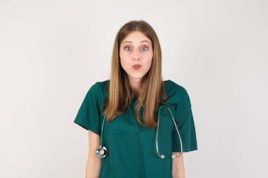  Genç bayan doktor dudaklarını büzüyor, kameraya bakıyor, insan yüz ifadeleri...