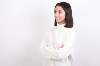 Elleri çapraz olan genç bir kadın fotokopi alanına bakıyor.