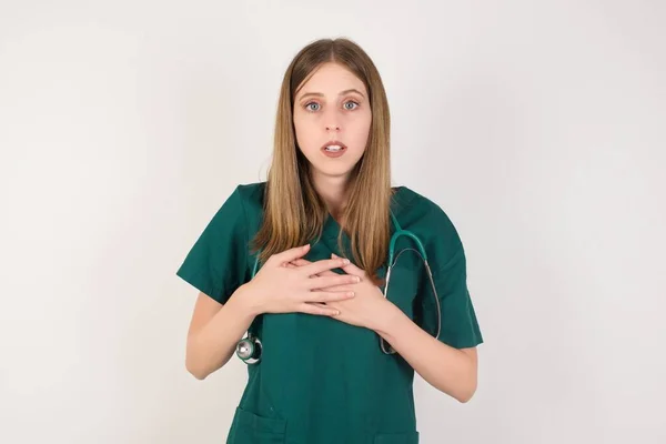 Σοκαρισμένη Νεαρή Γυναίκα Γιατρός Κρατώντας Χέρια Στο Στήθος — Φωτογραφία Αρχείου