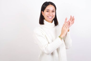 Genç kadın alkışlıyor ve alkışlıyor mutlu ve neşeli, gülümseyen gururlu eller birlikte.