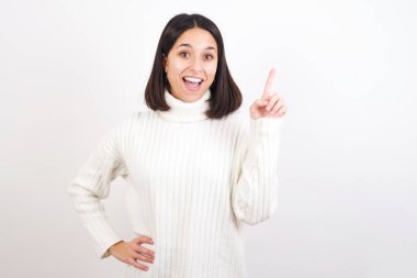 Genç bir kadın parmak kaldırıyor, fikir üretiyor ve poz veriyor.