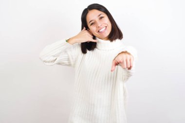 Genç bir kadın neşeyle gülümsüyor ve kamerayı işaret ediyor. Sonra seni arıyor, telefonla konuşuyor.